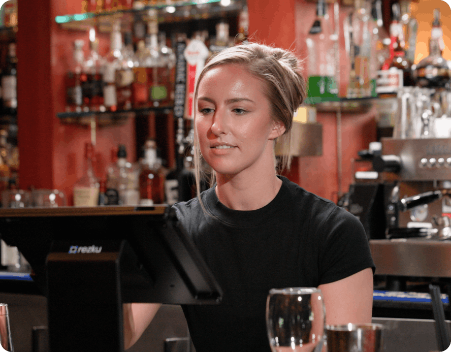Restaurant staff managing third-party delivery orders on a Rezku POS tablet at the bar