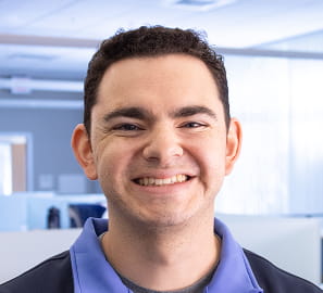 Rezku team member in a polo shirt smiling in a bright modern office